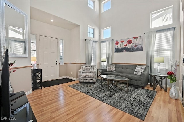 living room featuring a high ceiling, wood finished floors, and baseboards