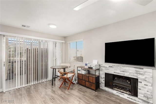 living area with a fireplace and light hardwood / wood-style flooring