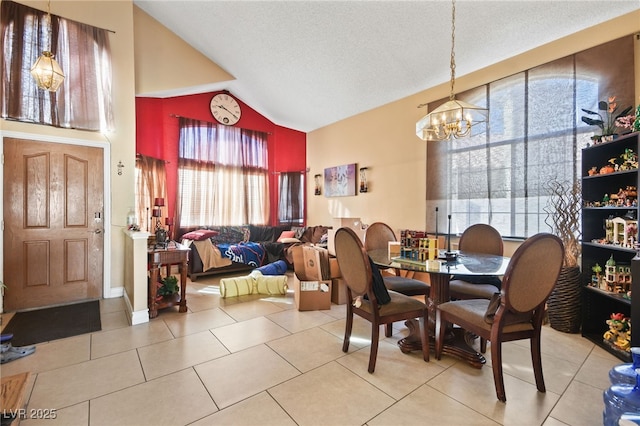 dining space featuring plenty of natural light, light tile patterned flooring, a chandelier, and vaulted ceiling