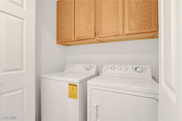 laundry room featuring washing machine and dryer and cabinets