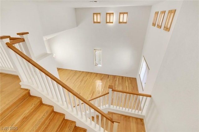 stairway featuring hardwood / wood-style floors and a high ceiling