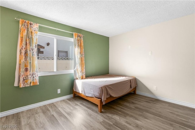 unfurnished bedroom with hardwood / wood-style floors and a textured ceiling