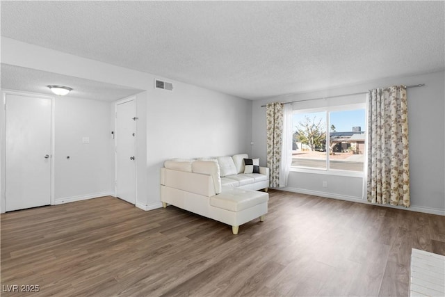 unfurnished living room featuring hardwood / wood-style floors and a textured ceiling