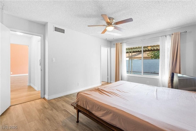 bedroom featuring ceiling fan, a textured ceiling, and light hardwood / wood-style flooring