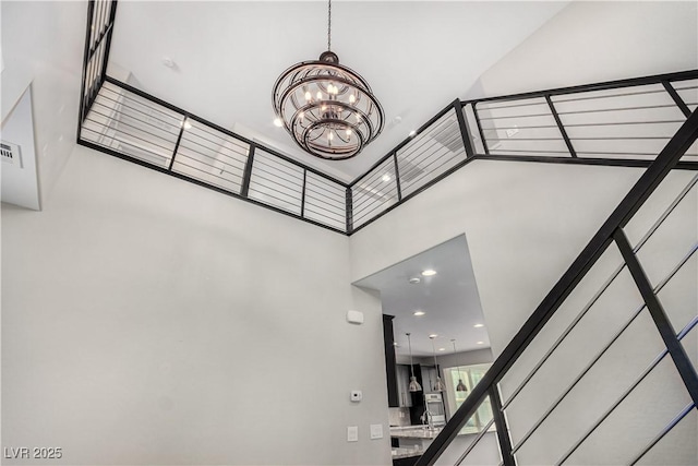 stairs featuring a chandelier and a high ceiling