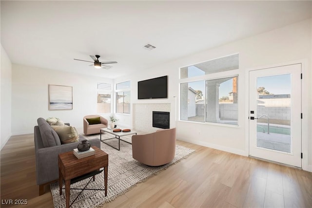 living room with ceiling fan and light wood-type flooring