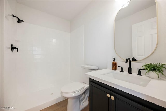 bathroom with vanity, toilet, wood-type flooring, and a shower