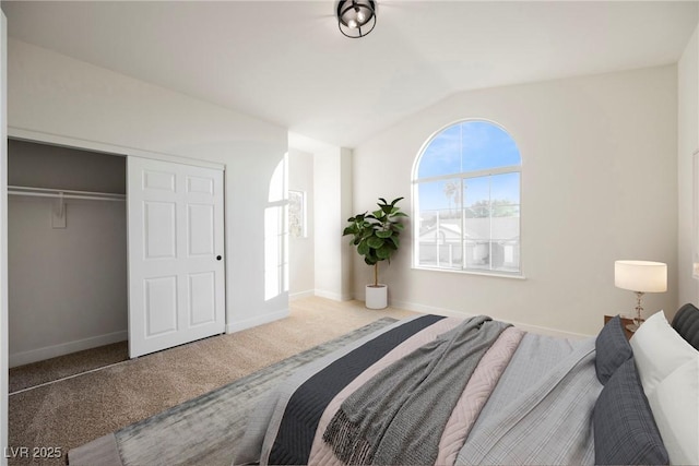 carpeted bedroom featuring vaulted ceiling and a closet