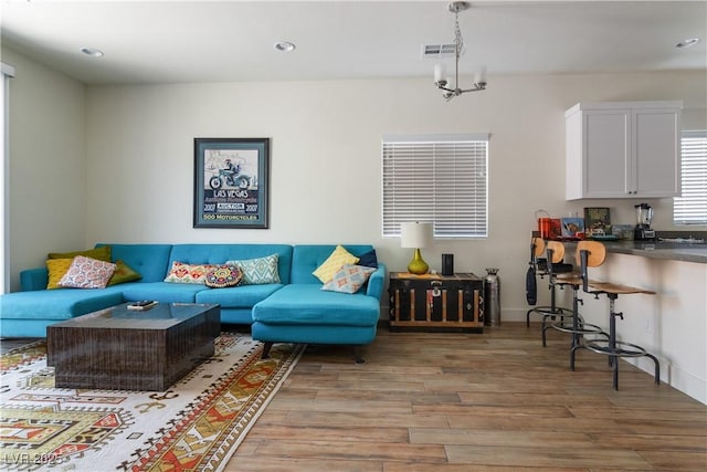 living room with hardwood / wood-style flooring and a notable chandelier