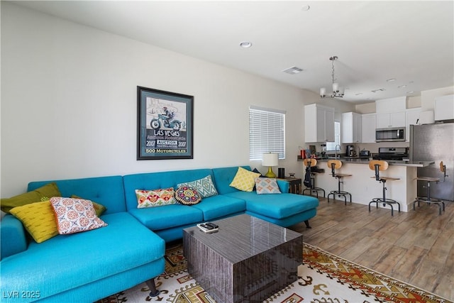 living room with an inviting chandelier and wood-type flooring