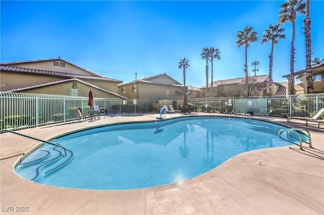 pool with a patio and fence