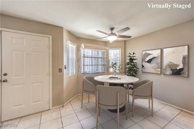 dining space featuring baseboards, a ceiling fan, and light tile patterned flooring