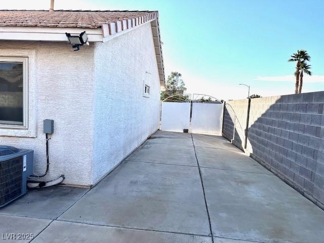 view of property exterior with a patio and central AC