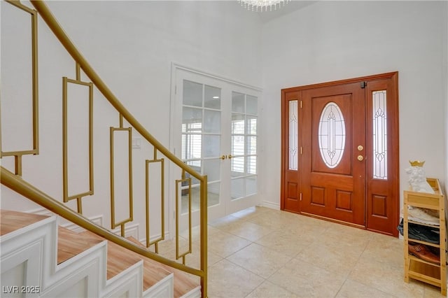 foyer featuring french doors, a high ceiling, and light tile patterned floors