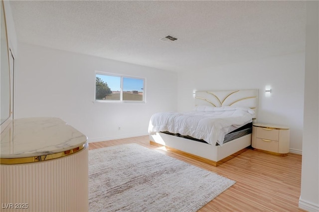 bedroom with hardwood / wood-style flooring and a textured ceiling