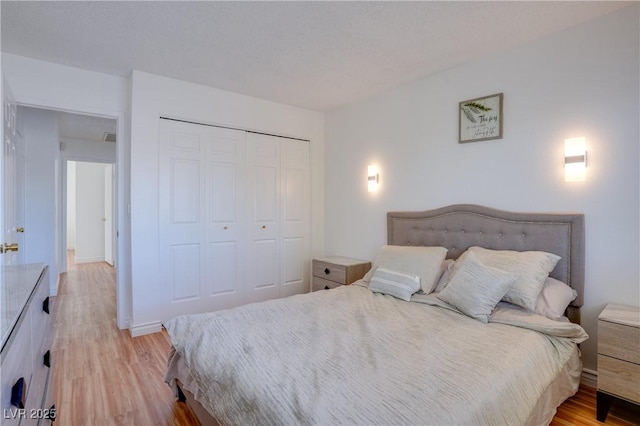 bedroom with light hardwood / wood-style flooring and a closet