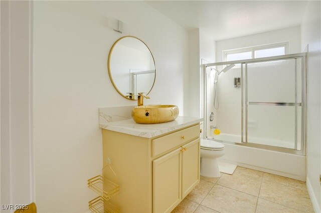 full bathroom featuring vanity, tile patterned floors, enclosed tub / shower combo, and toilet