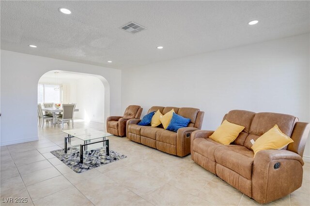 living room with light tile patterned flooring and a textured ceiling