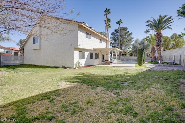 back of property featuring a lawn and a patio