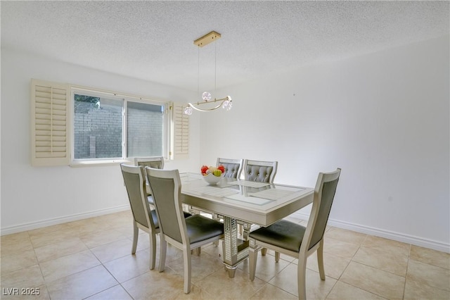 dining space featuring light tile patterned floors and a textured ceiling