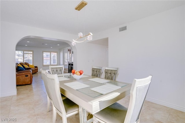 tiled dining room featuring an inviting chandelier