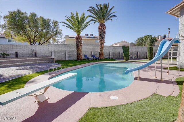 view of pool featuring a patio, a yard, a diving board, and a water slide