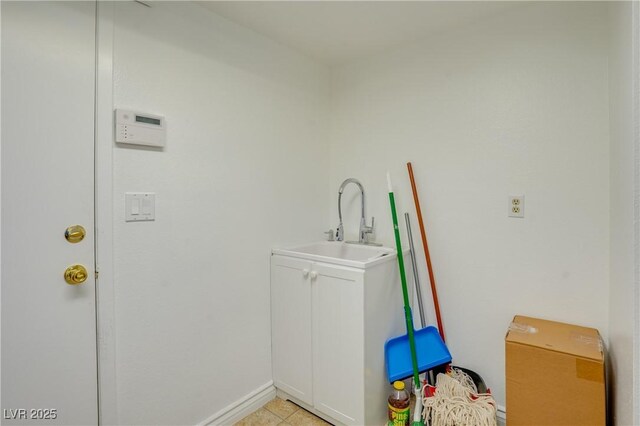 laundry room with light tile patterned flooring and sink