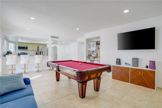 recreation room with light tile patterned floors, built in features, billiards, and a textured ceiling