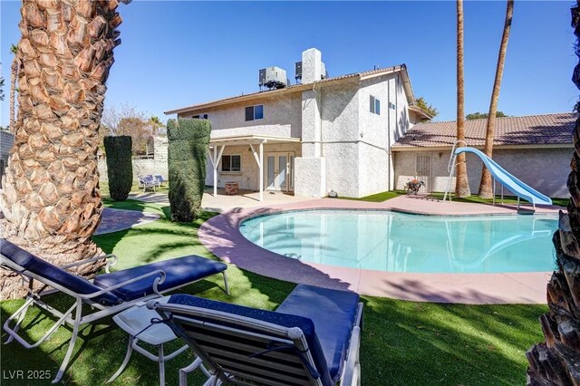 view of pool with central AC unit, a yard, a patio area, and a water slide