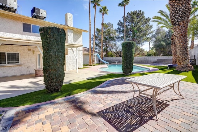 view of patio / terrace with a fenced in pool and central AC unit