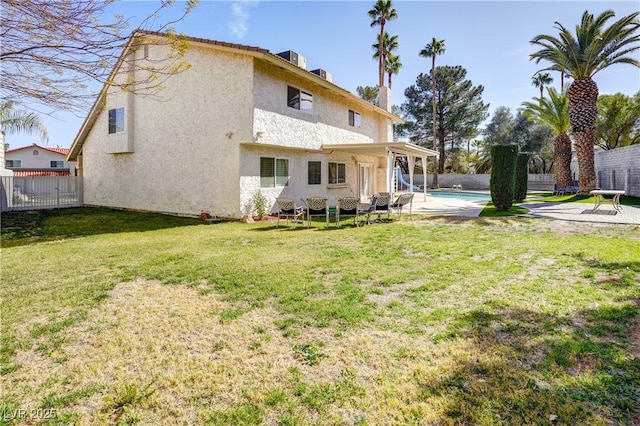 rear view of property with cooling unit, a fenced in pool, a patio area, and a lawn