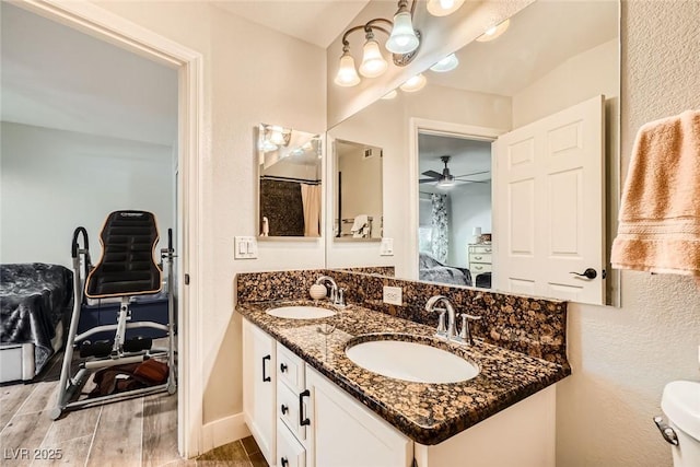 bathroom featuring a sink, connected bathroom, wood tiled floor, and double vanity