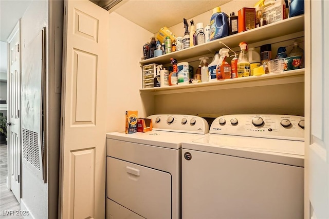 laundry room with washing machine and clothes dryer, laundry area, and light wood-style flooring