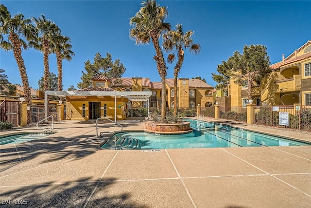 community pool featuring a patio, fence, and a residential view