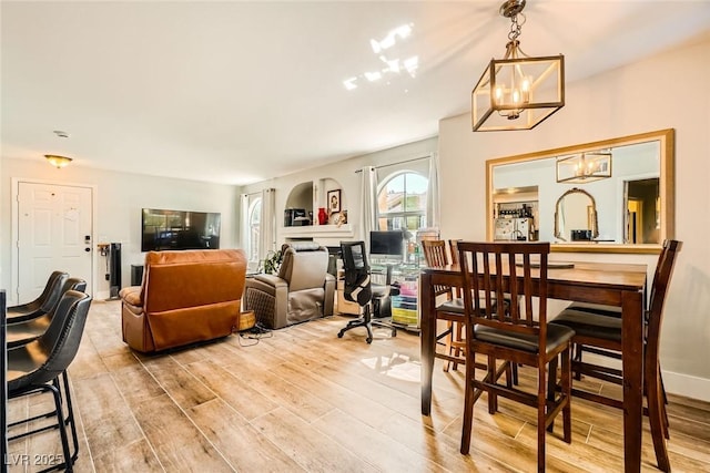 dining space with baseboards and light wood finished floors