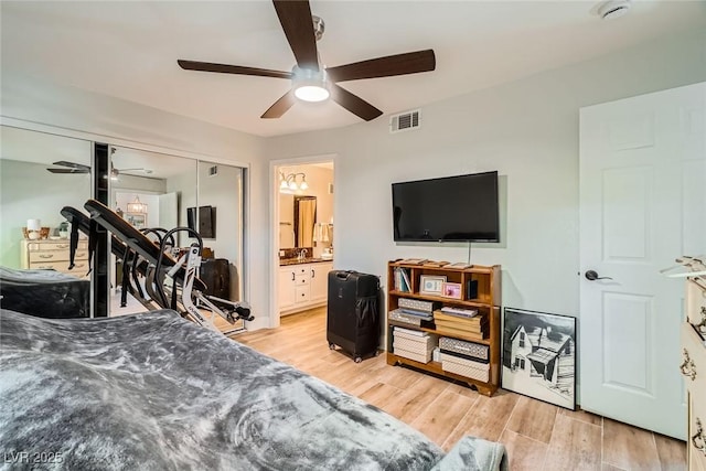 bedroom with light wood-type flooring, visible vents, ensuite bathroom, a closet, and ceiling fan