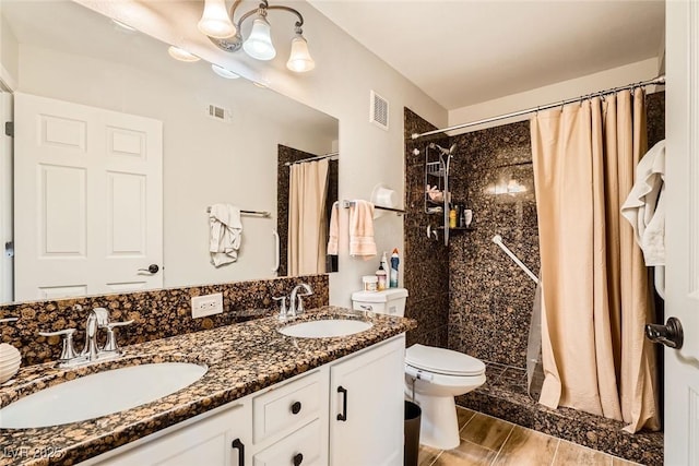 bathroom with a sink, visible vents, toilet, and a shower stall