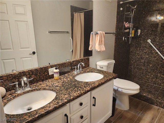 7950 W Flamingo Rd Unit 1081, Las Vegas, NV 89147 - bathroom featuring a tile shower, double vanity, and wood finish floors