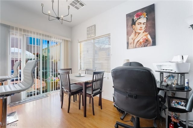 dining space featuring hardwood / wood-style flooring and a chandelier