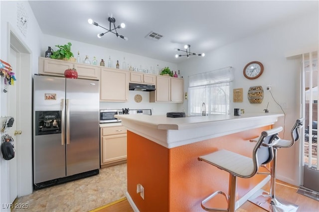 kitchen featuring stainless steel appliances, a breakfast bar, sink, and kitchen peninsula