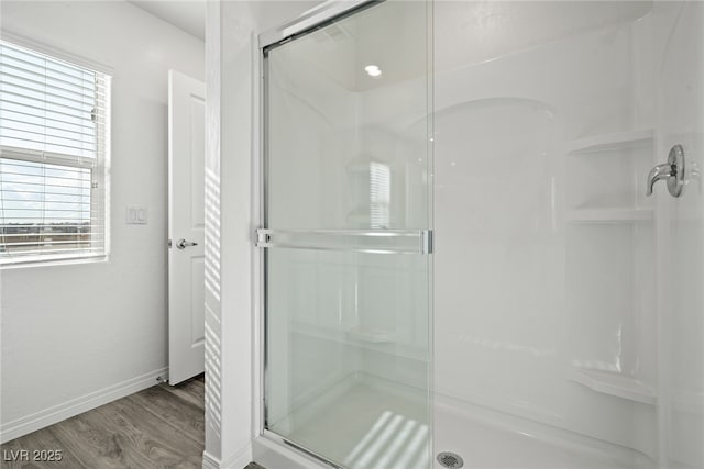bathroom with wood-type flooring and a shower with shower door