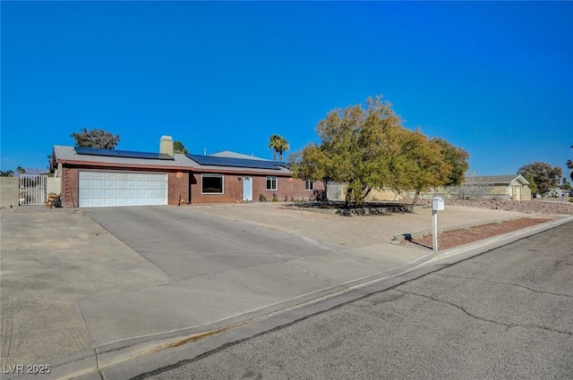 view of front of property featuring a garage and solar panels