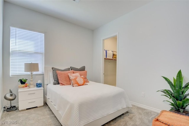 carpeted bedroom featuring a walk in closet