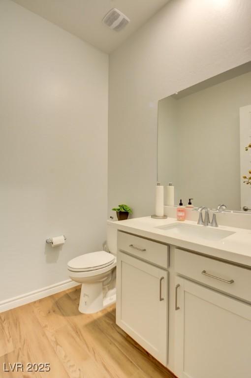 bathroom with vanity, wood-type flooring, and toilet