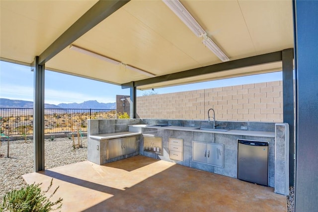 view of patio featuring area for grilling, a mountain view, and sink