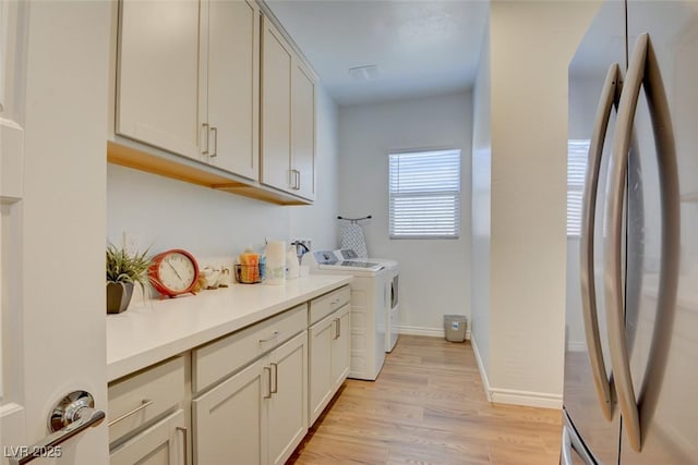 laundry room featuring washer and dryer and light hardwood / wood-style flooring