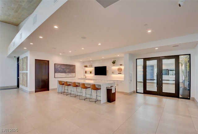 kitchen featuring a large island, a kitchen bar, and french doors