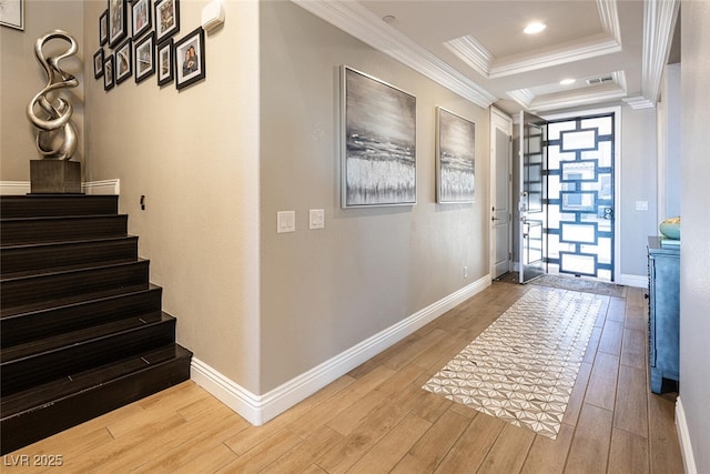 corridor featuring ornamental molding, a raised ceiling, and light hardwood / wood-style flooring