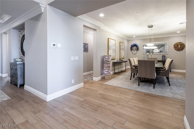 dining area featuring ornamental molding and light hardwood / wood-style flooring