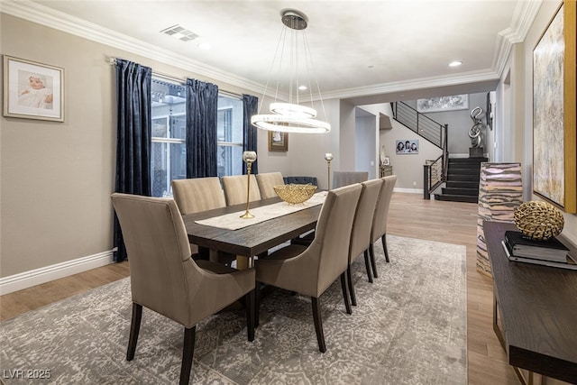 dining room with hardwood / wood-style flooring and crown molding